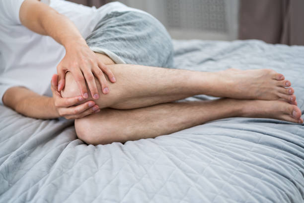 istock Knee pain, man suffering from ache in the home interior 1327587619