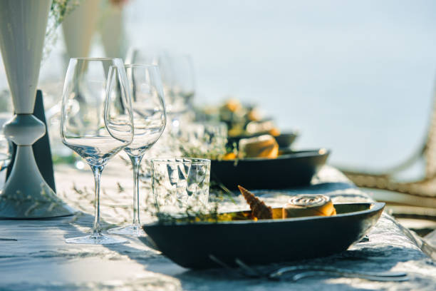 istock Festive table decor wine glasses and table setting in on beach.. Focus on dish with wineglass 1327587727