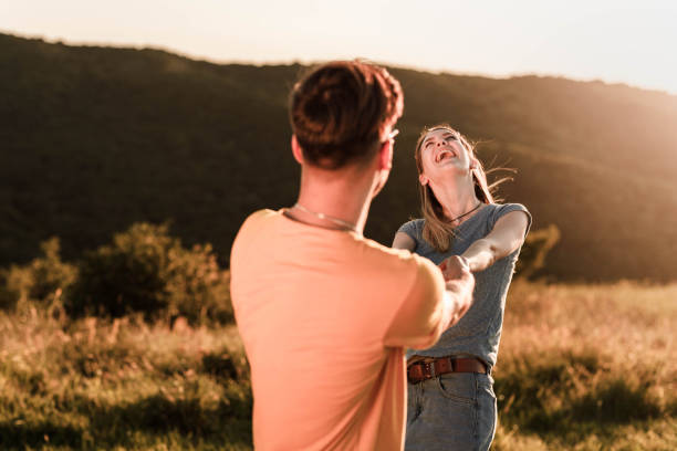 istock Young carefree couple having fun while spinning in a meadow. 1327587793