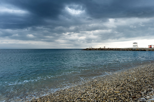 Scenic landscape of the beach and dark blue sea, cloudy sky before a thunderstorm. A bay in the resort village of Nebug, Krasnodar Territory.