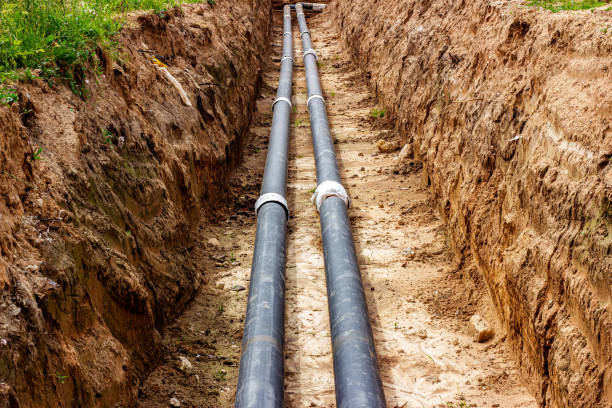 istock Installation of the distribution unit of heating and water supply network. Frame for connecting pipes in the trench of ground 1327591087