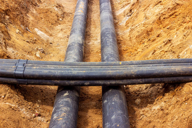 istock Installation of the distribution unit of heating and water supply network. Frame for connecting pipes in the trench of ground 1327591109
