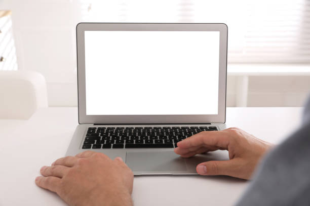istock Man with modern laptop at white table indoors, closeup. Space for design 1327592174