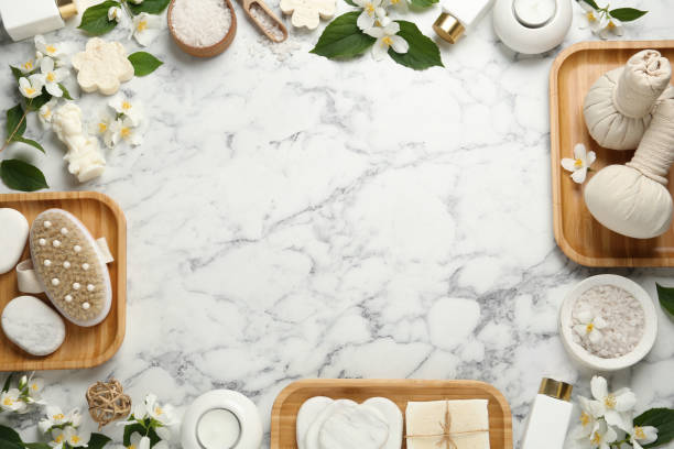 istock Jasmine flowers and set of spa essentials on white marble table, flat lay. Space for text 1327592178