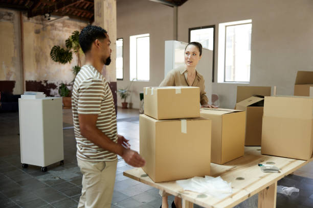 istock Business people unpacking and moving into new office space. 1327592635