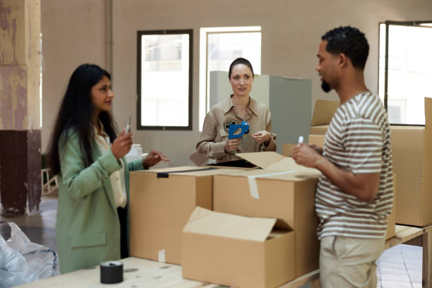 istock Business people moving into a new office, packing and unpacking. 1327592685