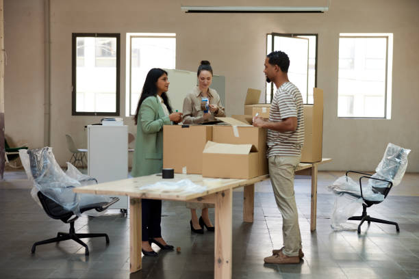 istock Business people packing and unpacking in a new office. 1327592687