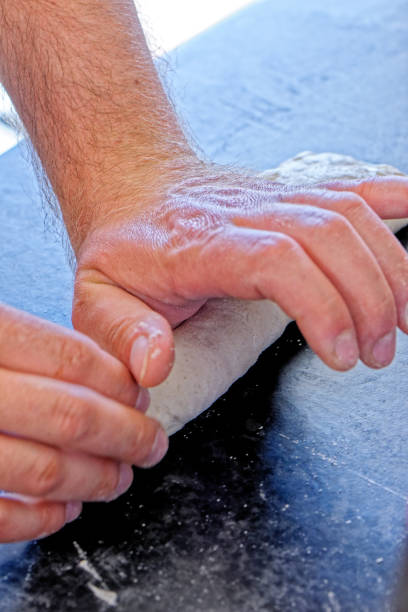 istock Close-up view of professional baker preparing bread dough in a kitchen 1327597124