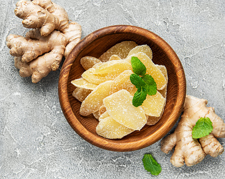 Sweet and spicy candied ginger on a grey concrete background