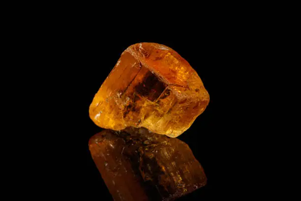 Macro stone mineral yellow topaz on a black background close-up