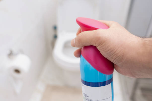 hand sprays a toilet with air freshener - air freshener imagens e fotografias de stock