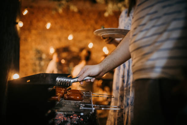 istock Man frying sausages on grill 1327600073