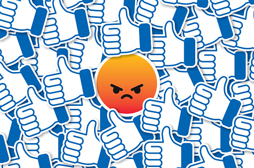 Vector illustration of an angry emoticon amongst a pile of thumbs up. Social media contrary position, trolling, going against the crowd, against the grain, showing attitude concept illustration.