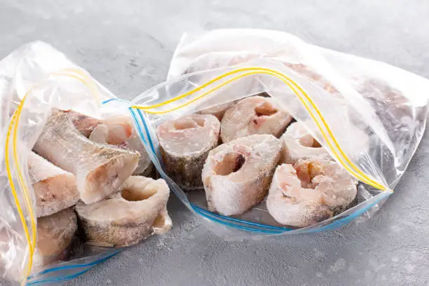 Photo of Frozen fish in a plastic bag on a table. Frozen food