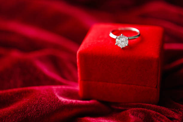 istock Diamond ring with jewelry gift box on red fabric background 1327610223