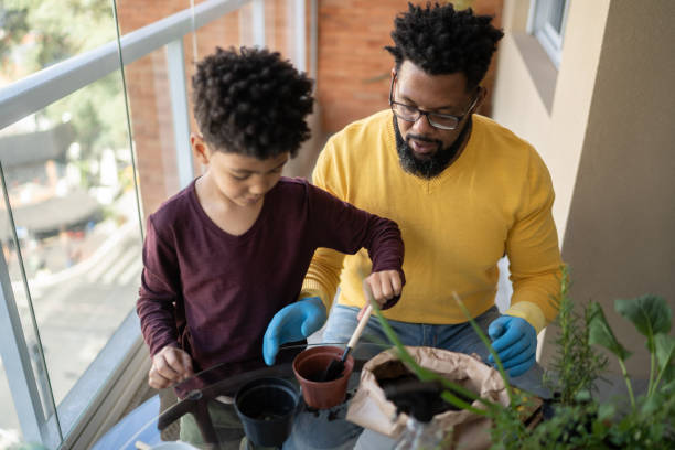 istock Father and son cultivating plants together at home 1327611301
