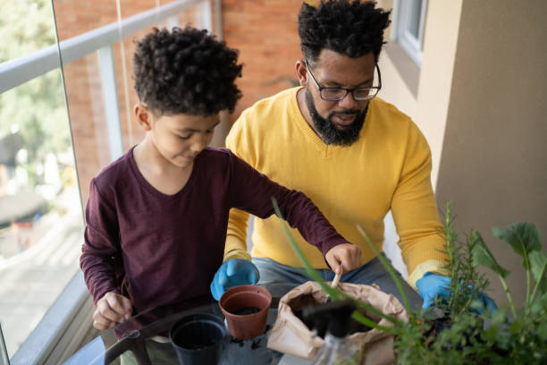 istock Father and son cultivating plants together at home 1327611320