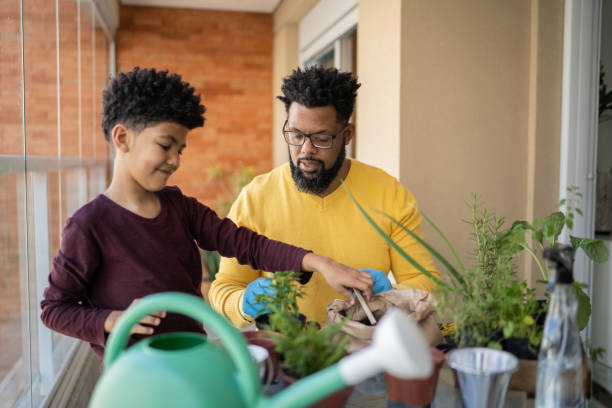 istock Father and son cultivating plants together at home 1327611329