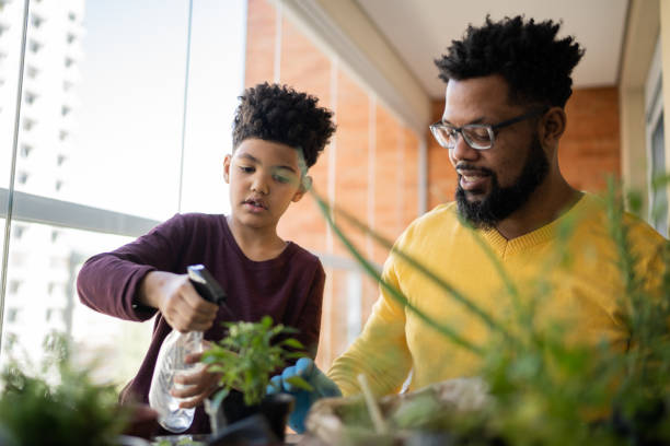 istock Father and son cultivating plants together at home 1327611332