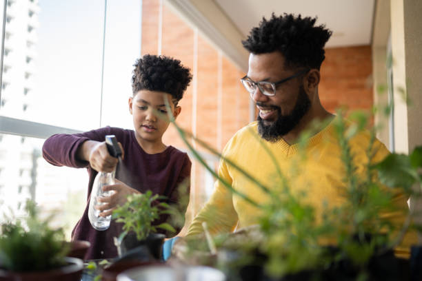 istock Father and son cultivating plants together at home 1327611348