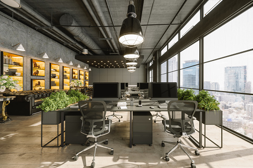Interior of a modern luxurious open plan office space with dark gray furniture and city view.