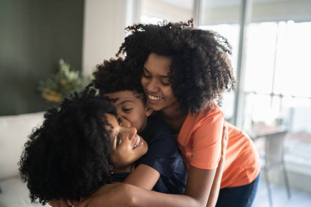 istock Kids embracing mother at home 1327612379