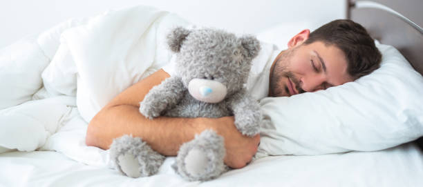 istock The man sleeping with a soft toy on the white background 1327612383