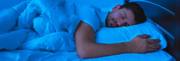 istock The handsome man sleeping on the bed. evening night time 1327612409