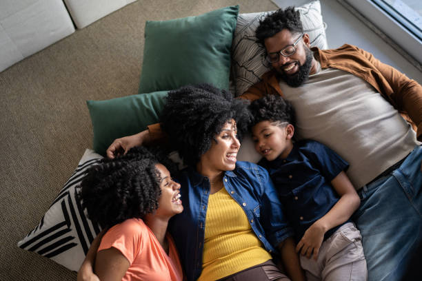 Happy family together lying on the ground at home Happy family together lying on the ground at home family at home stock pictures, royalty-free photos & images