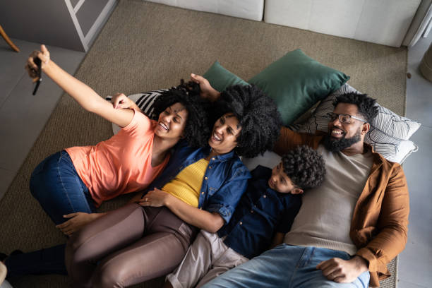 istock Family using mobile phone lying on the floor at home 1327612433
