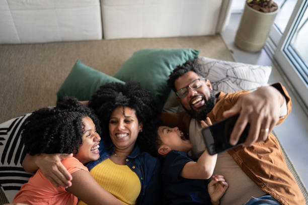 istock Family using mobile phone lying on the floor at home 1327612451