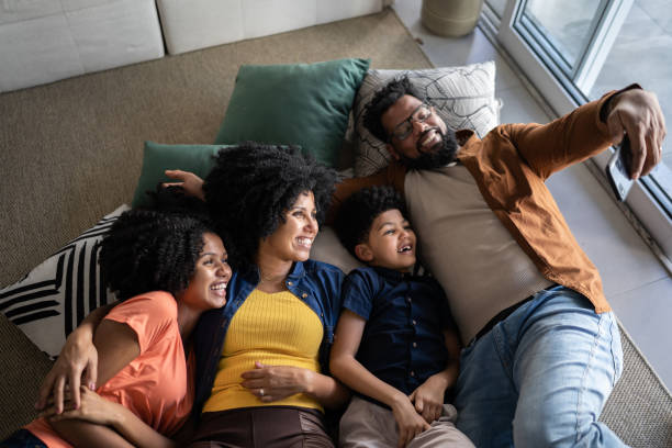 istock Family using mobile phone lying on the floor at home 1327612465