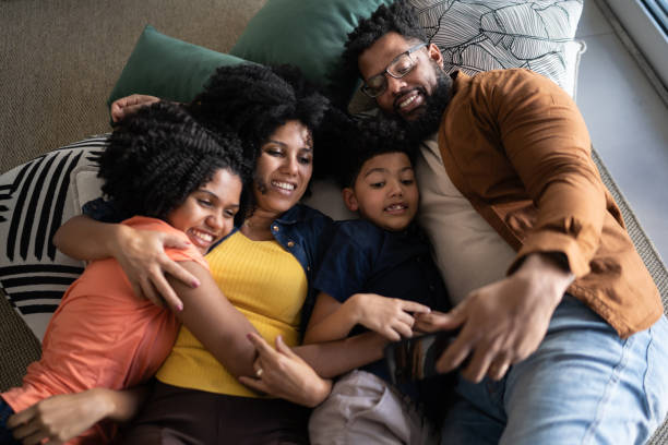 istock Family using mobile phone lying on the floor at home 1327612471