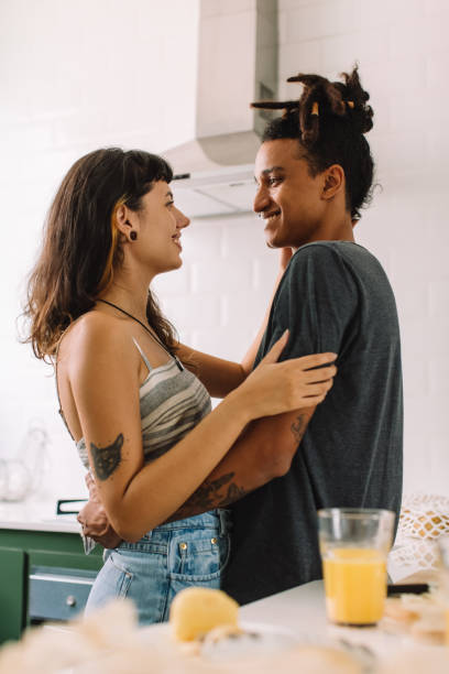 istock Romantic young couple smiling at each other in the kitchen 1327612599