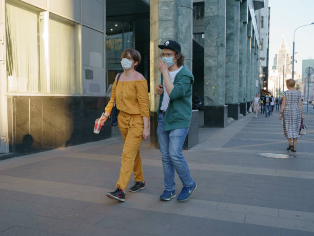 jóvenes con mascarillas quirúrgicas durante la pandemia de coronavirus en moscú - human face heterosexual couple women men fotografías e imágenes de stock