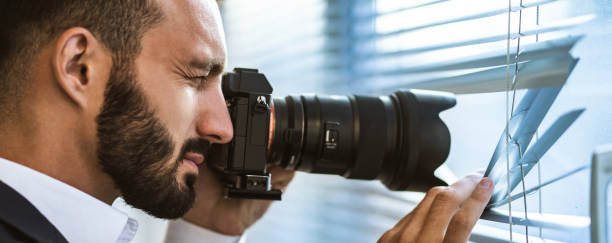 istock The man with a camera photographing through the blinds 1327613236