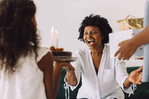 自宅で誕生日のお祝い - grandmother giving gift child ストックフォトと画像