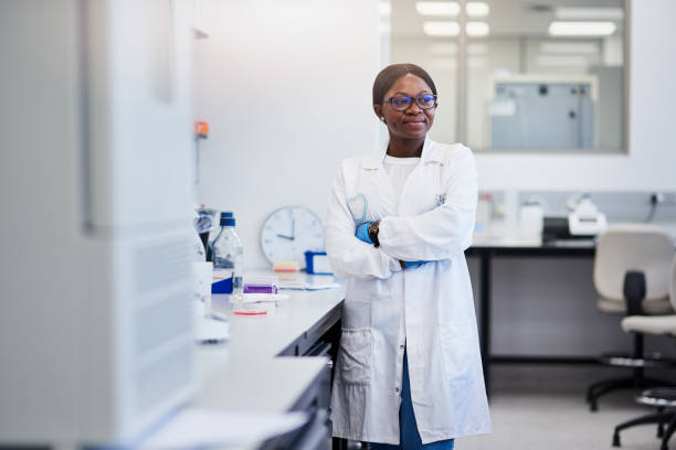colpo di un giovane scienziato che conduce ricerche mediche in laboratorio - research smiling scientist women foto e immagini stock