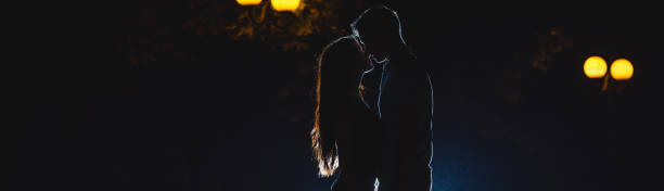 la pareja se besa en el callejón oscuro. tiempo nocturno - narrow alley fotografías e imágenes de stock