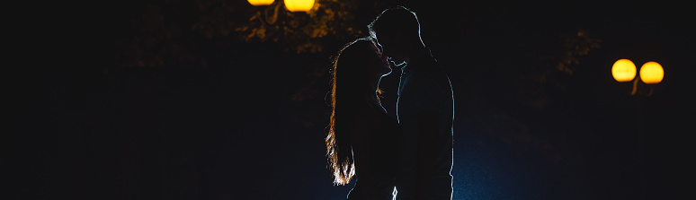 The couple kissing on the dark alley. night time