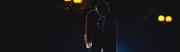 Photo of The couple kissing on the dark alley. night time