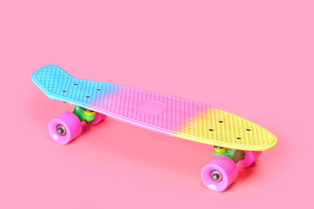 istock rainbow plastic Penny board skateboard isolated on pink background 1327614216
