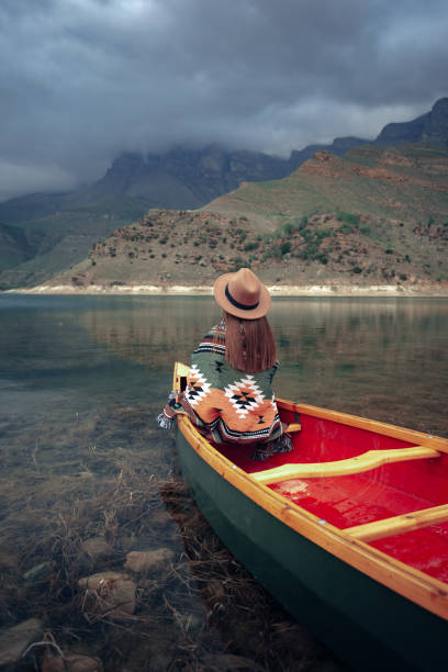 istock Young woman in hat canoeing on a lake 1327614302