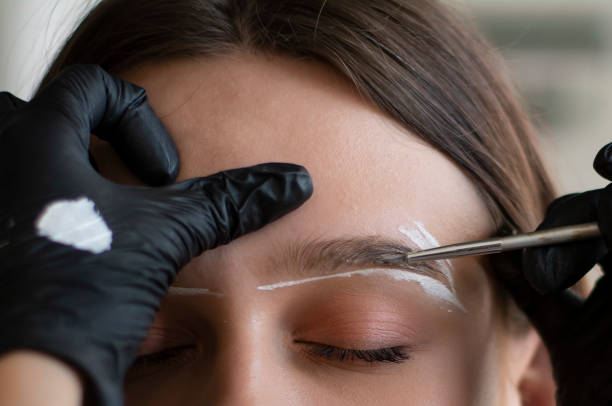 femme pendant la procédure de teinte des sourcils, vue rapprochée - colorant capillaire photos et images de collection