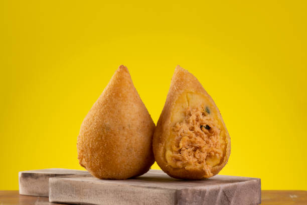 Fried coxinha on wooden board with yellow background Fried coxinha on wooden board with yellow background. coxinha stock pictures, royalty-free photos & images