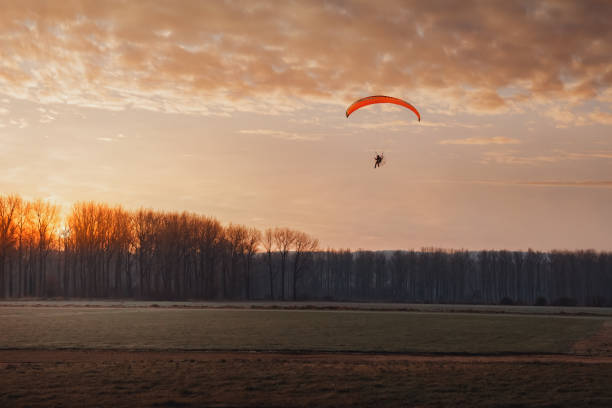 istock paragliding at sunset/sunrise 1327617582