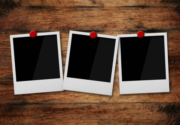 istock Empty instant photo frames pinned on wooden wall 1327618999