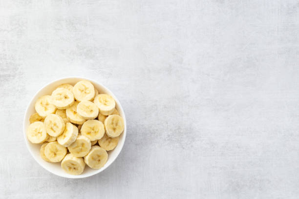 istock Many banana slices in white bowl. Top view 1327619319