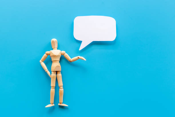 istock Wooden man figure presenting and showing on speech bubble banner 1327620984