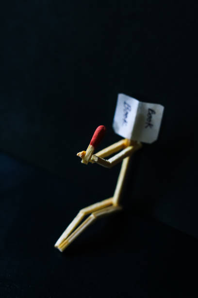 istock Matchstick concept and ideas. Book reading concept and ideas. Matchstick reading a book with black background. 1327621844
